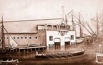 The 10-oared barge Henrietta from the Teutonia Boat Club passes the Detroit Boat Club at the foot of Jos. Campau in 1978. The DBC had not yet moved to Belle Isle. 