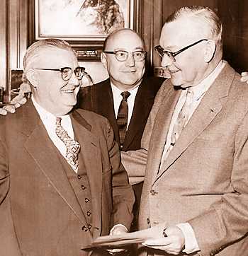 Roy Dossin, left, presents a check for $125,000 to the Detroit Historical Commission toward the construction of Marine Museum on Belle Isle. At center is Leonard Simons, vice president of the Historical Commisssion, and George Stark, commission president.