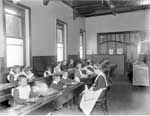 Image of children seated at long desks in school room