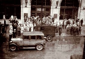 A crowd of curious onlookers gathers in front of the Detroit News after the robbery. 