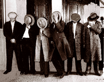 Gangsters: Purple Gang members hide their faces from the camera in May 1929 after they were arrested on charges of providing protection to Detroit narcotics dealers. Over the years gang members were accused of hijacking, bootlegging, extortion, kidnaping and murder.