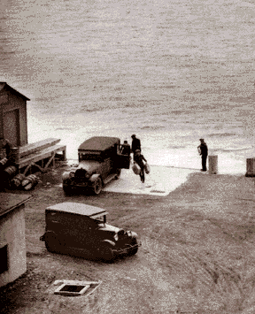 The Detroit River was a highway for Canadian liquor during Prohibition. A Detroit News photographer hid in a coal elevator to get this picture of rumrunners loading their cars at the foot of Riopelle in 1929.