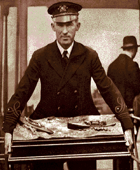 Gar Wood carries the Harmsworth Trophy to the United States for the first time in 1920. The bronze plaque, donated by Lord Northcliffe in 1903, goes to the victor of the international powerboat competition. 